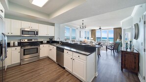 Una cocina moderna con armarios blancos, electrodomésticos de acero inoxidable y una isla grande.