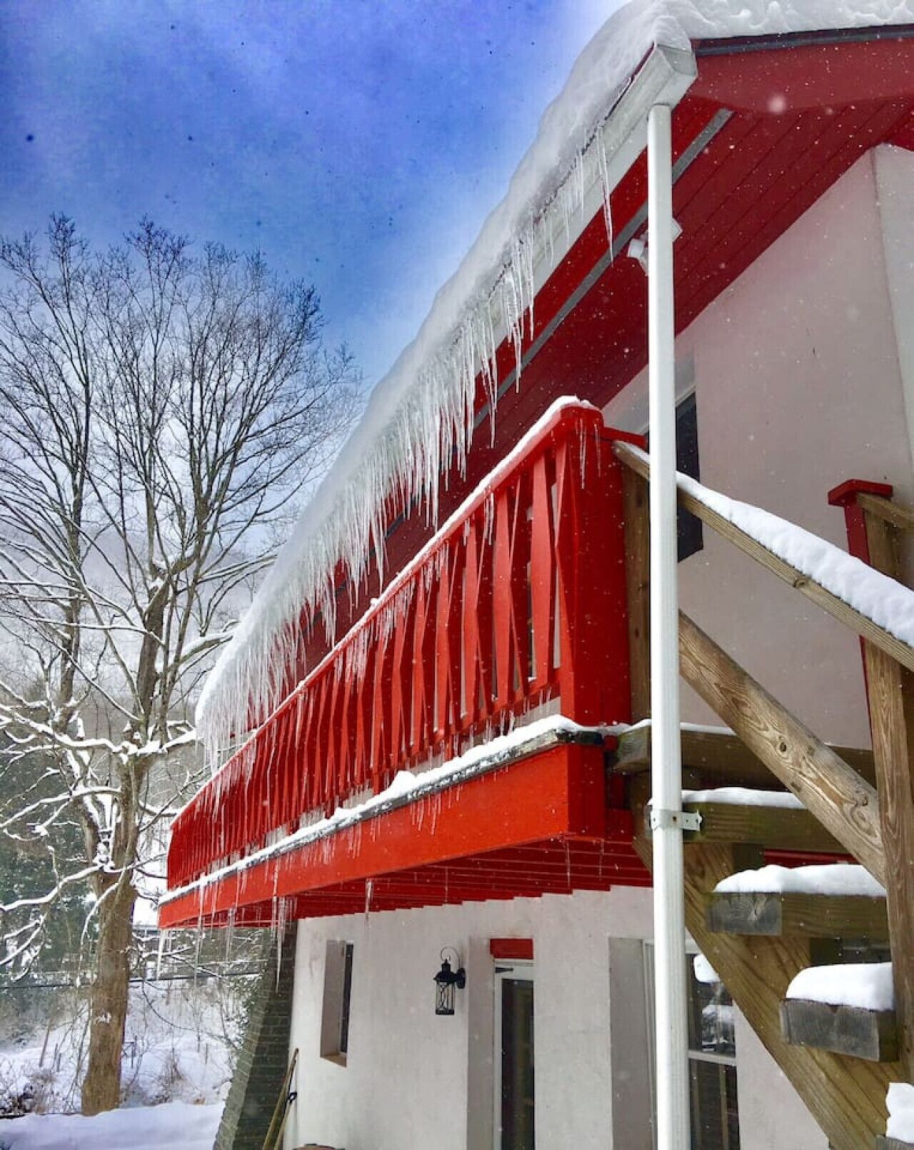 Un bâtiment doté d’un balcon rouge et d’une porte blanche.
