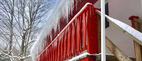 Un bâtiment doté d’un balcon rouge et d’une porte blanche.