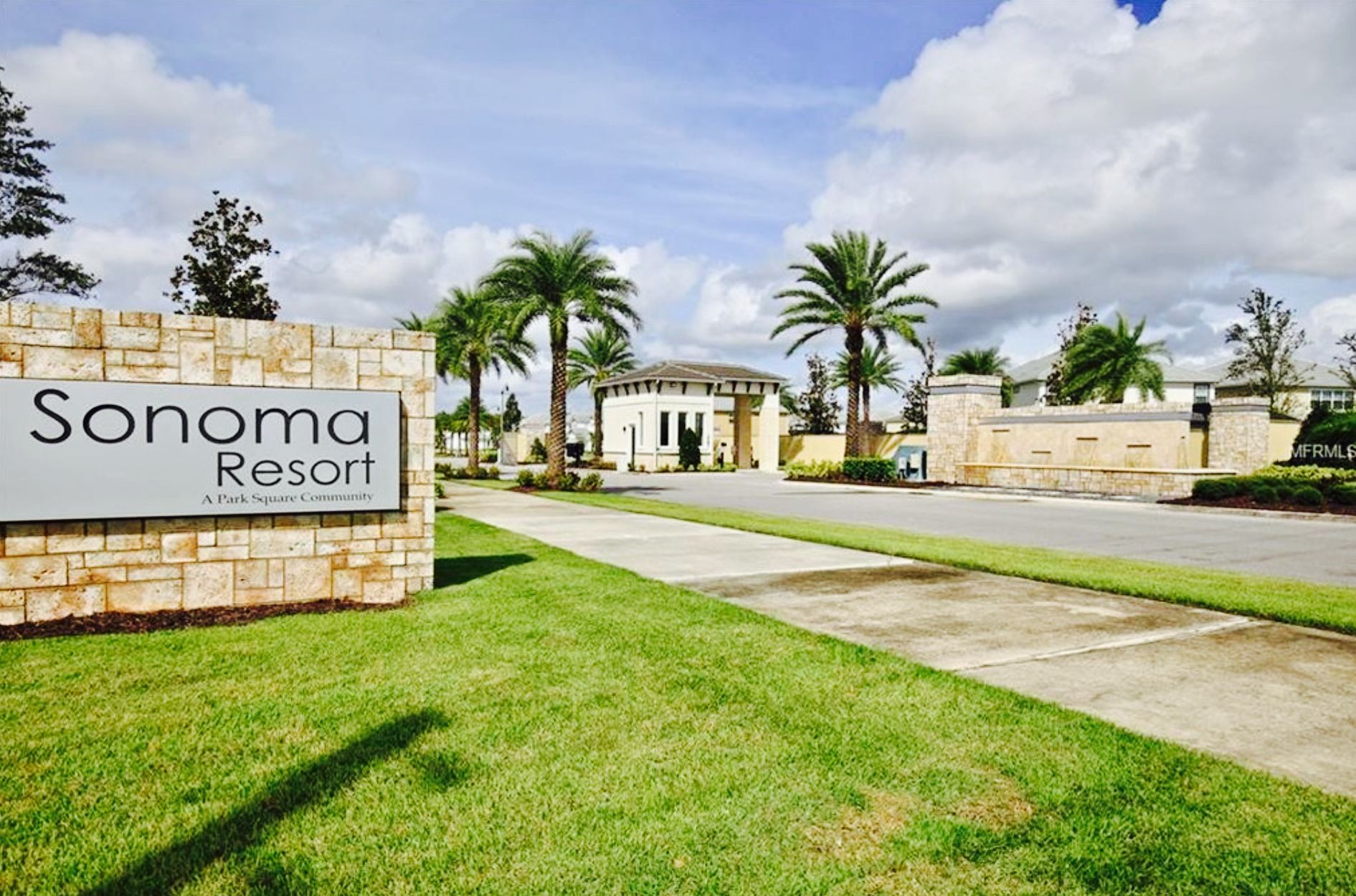 A sign for Sonoma Resort, a park square community with a central building, palm trees, and a clear sky.