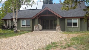 A house with a gravel driveway, a stone pillar, and a covered patio area. - Modern Home Secluded in the Mountains With Breathtaking Views in Divide CO (Divide)