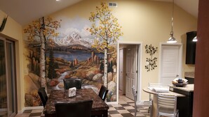 A dining area with a mural of a mountainous landscape, a checkered floor, and a dining table with chairs. - Modern Home Secluded in the Mountains With Breathtaking Views in Divide CO (Divide)