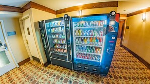 Un couloir avec deux distributeurs automatiques de boissons et un panneau indiquant l’emplacement de la salle de sport.