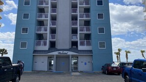 Ein mehrstöckiges Hotel mit einem zentralen vertikalen Element, Balkonen und einem Schild mit der Aufschrift "Westwind".