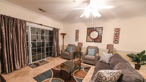 A living room with a sofa, two armchairs, a coffee table, a floor lamp, and a potted plant. - Beautiful private end unit! Featuring 2b/2b near swimming pool.   (Myrtle Beach)