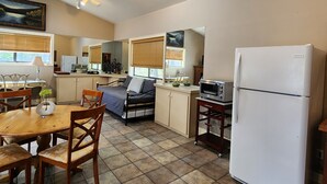 A compact kitchen with a dining area, a bed, and a refrigerator. - Convenient in town location (Beaver Island)