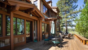 A wooden deck with outdoor seating, a hot tub, and a view of a golf course. - Dog-Friendly Villa, Steps Away From Old Greenwood's Driving Range! (Truckee)