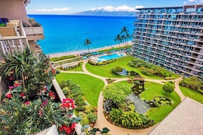 Un hotel con piscina, un jardín con estanque y vista al océano.