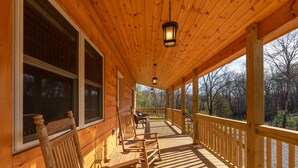A wooden deck with a railing, wooden chairs, and a table. - Beautiful Private Cabin, adjacent to the National Forest (Luray)