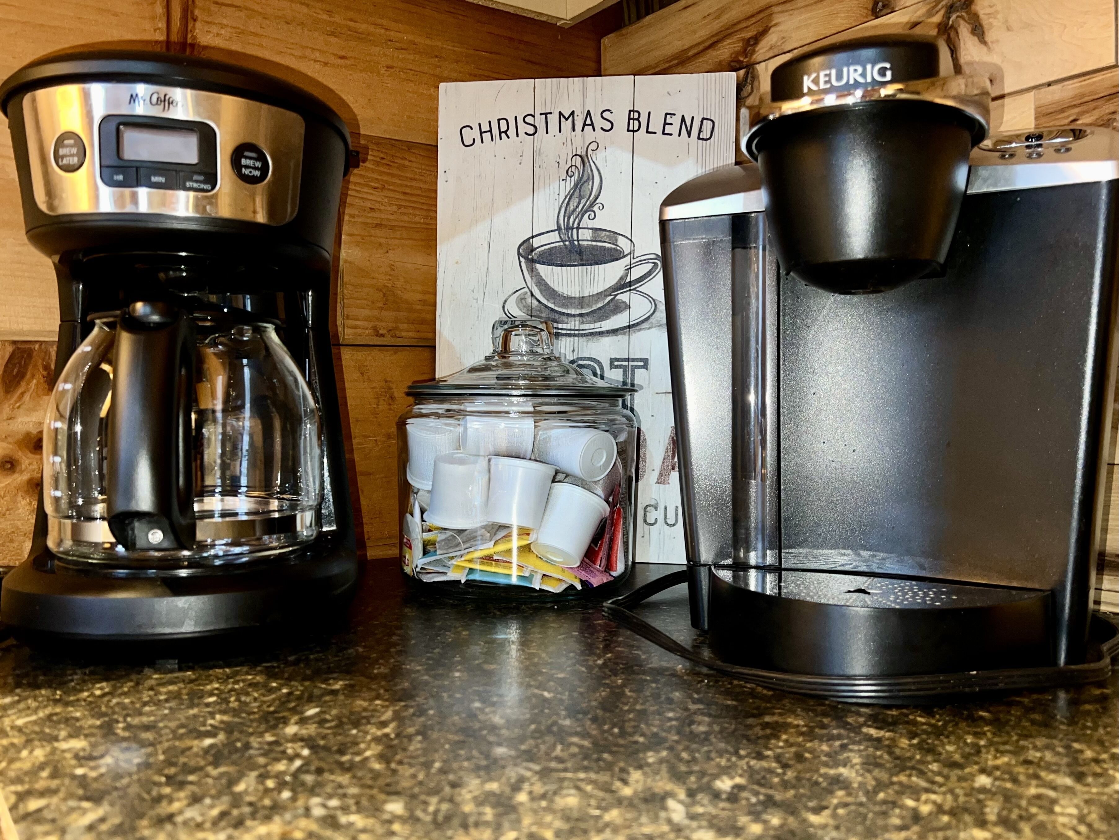 A coffee maker, a Keurig, and a glass carafe on a kitchen counter.