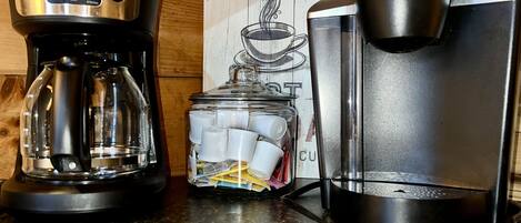 A coffee maker, a Keurig, and a glass carafe on a kitchen counter.