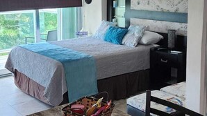 A bedroom with a bed, bedside tables, a ceiling fan, and a window with a view.