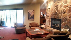 A cozy lobby with a stone fireplace, comfortable seating, and a large window. - A Canyon's Getaway! 
Perfect for mountain and outdoor lovers (Park City)