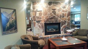 A lobby with stone walls, a fireplace, and seating areas. - A Canyon's Getaway! 
Perfect for mountain and outdoor lovers (Park City)
