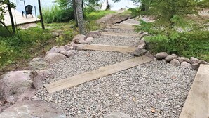 Un sendero de grava con escalones de madera que conducen a un muelle.