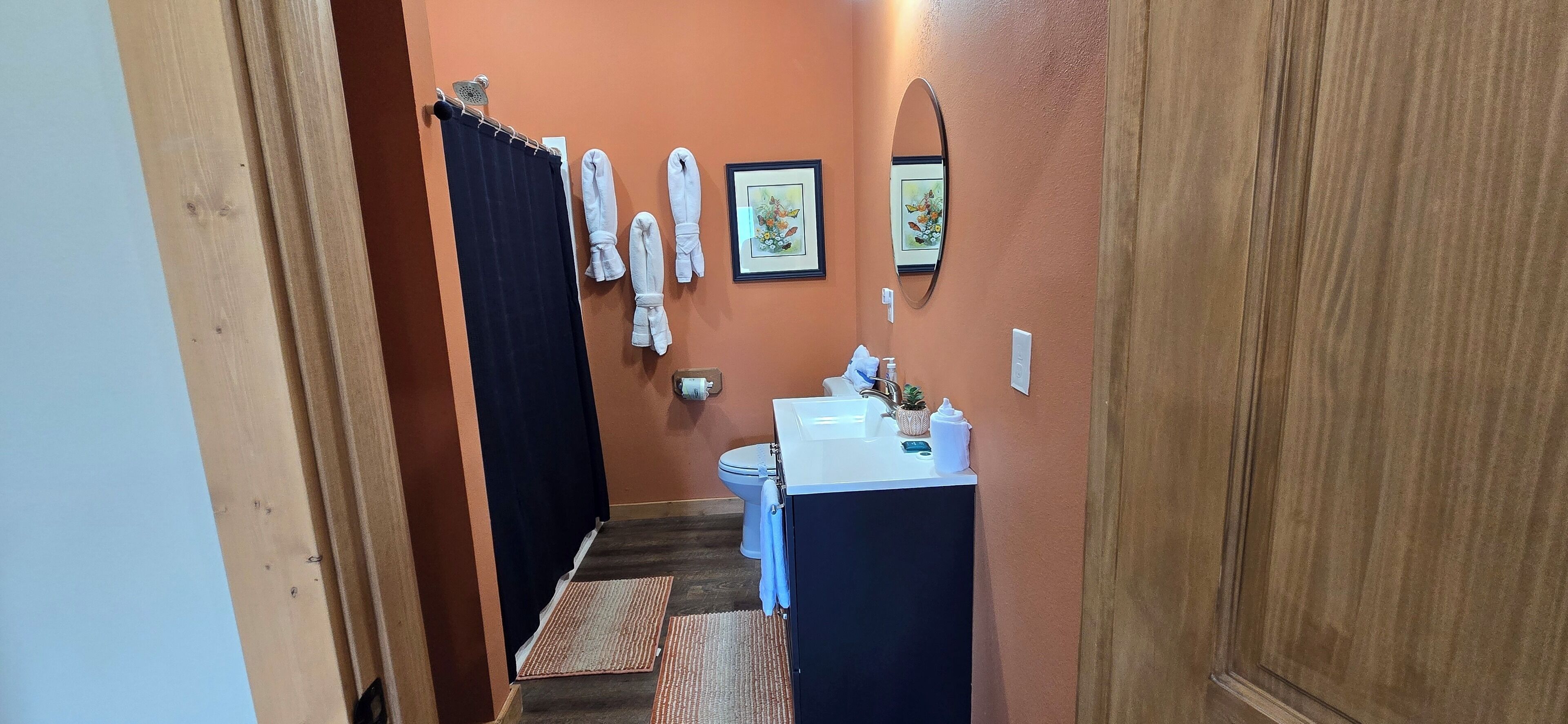 A bathroom with a toilet, sink, towel rack, and a mirror.
