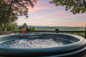 A hot tub with a view of a forest and mountains. - Secluded, luxurious cabin perched above Eagle Fork Creek with sunrise views. (Smithville)