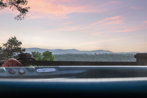 A view from inside a vehicle, looking out at a landscape with mountains and trees under a pink sky. - Secluded, luxurious cabin perched above Eagle Fork Creek with sunrise views. (Smithville)