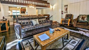 Ein gemütliches Wohnzimmer mit einer großen Couch, einem Couchtisch und einem Kamin.