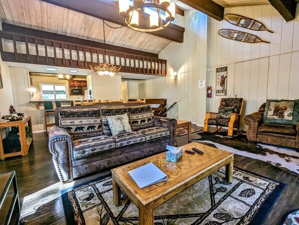 Ein gemütliches Wohnzimmer mit einer großen Couch, einem Couchtisch und einem Kamin.