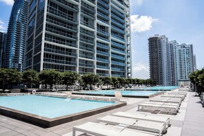 A modern hotel with multiple swimming pools, high-rise buildings, and a clear sky. - MVR - The Ultimate Brickell Balcony (Miami)