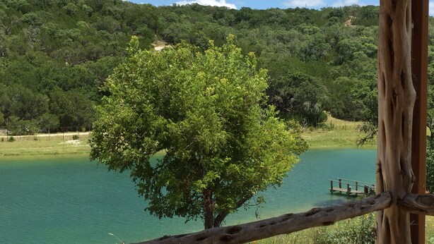A tree by a calm lake with a wooden fence in the foreground. - Mimi's Mansion At Stacy Ranch, Cabin On 120 Acres Between Ingram & Hunt, Tx (Ingram)