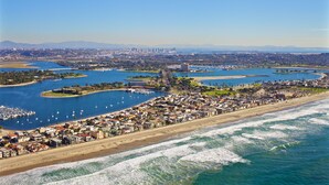 Eine Küstenstadt mit einer Marina, Strand und städtischen Gebäuden.