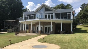A two-story house with a covered porch, a front entrance, and a landscaped yard. - Lake Escape - Unobstructed Views at our Group-Friendly Retreat! (Bracey)