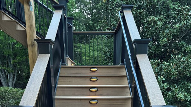 A wooden staircase with black railings and illuminated handrails. - Beautiful large family home with dock on Lake Keowee! (Seneca)