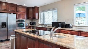 A modern kitchen with granite countertops, stainless steel appliances, and wooden cabinets.
