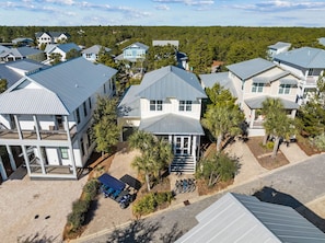 A residential area with multiple houses, each featuring a two-story structure with a grey roof and white walls. - Golf Cart & 4 Bikes! Next to Huge Resort Pool! Sandy Curls Cottage Highland Parks (Santa Rosa Beach)