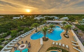 A resort with a swimming pool, lounge chairs, and palm trees. - Golf Cart & 4 Bikes! Next to Huge Resort Pool! Sandy Curls Cottage Highland Parks (Santa Rosa Beach)