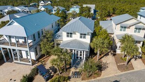 A residential area with multiple houses featuring blue roofs and white exteriors.