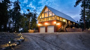 A large, two-story building with a prominent gable roof and large windows. It features two garage doors and a staircase leading to an upper level. - Spacious Prescott Forest Cabin, Game Room, 15 minutes to Downtown Prescott (Prescott)