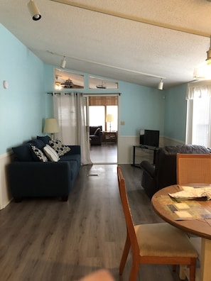 Relax in this open-plan living space with a sofa, dining table, and TV.