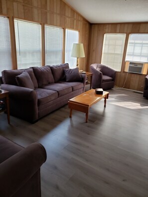 Relax in this inviting living room with a sofa, armchair, and coffee table, perfect for unwinding.