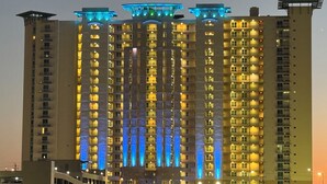 A high-rise building with multiple balconies and illuminated windows, likely a hotel or residential complex.