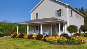 A two-story house with a covered porch and a well-maintained lawn.