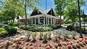 A building with a covered entrance, a sign reading "The Pavilion," and an American flag. - Stunning 6 bedroom 3.5 bath House in Bear Trap Dunes Community! Wifi Available, Pool, Fitness Center, Beach Shuttle, Tennis, Golf! (Ocean View)