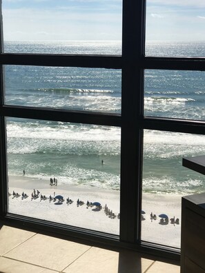 A view of the ocean through a window with a tiled floor.