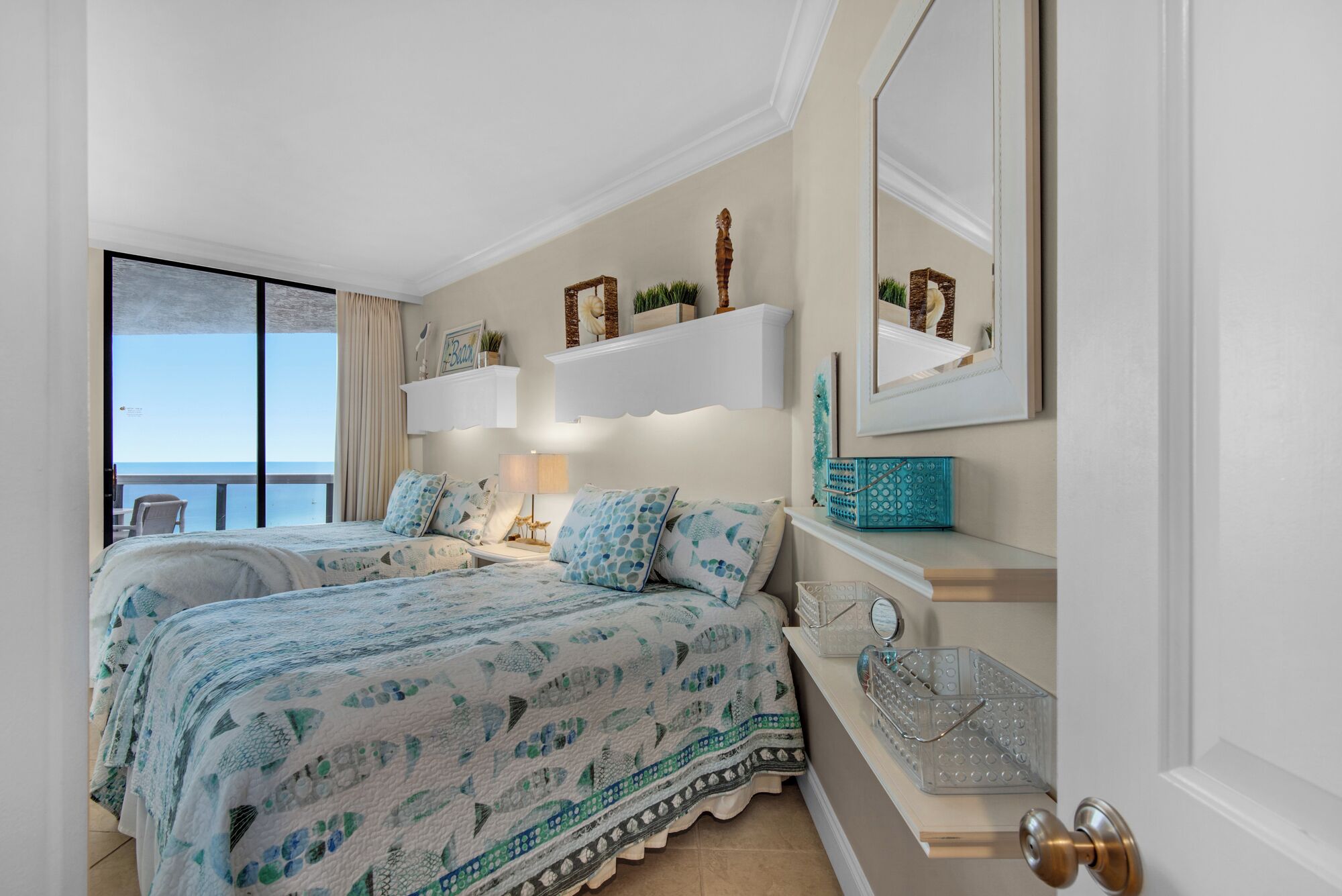 Ein Schlafzimmer mit zwei Betten, einem großen Fenster und einem Balkon.
