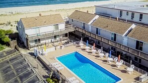 Un hotel con una piscina grande, mobiliario exterior y vistas a la playa.