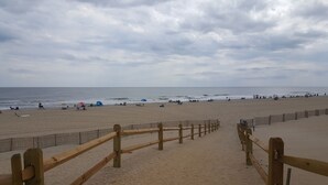 Una playa con un camino de madera que llega a la orilla.