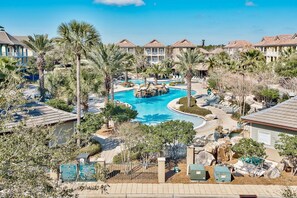 A resort with a central swimming pool, multiple guest villas, and palm trees. - Luxury Vacation Rental.  Great Location to the Beach, Harbor & Shopping (Destin)