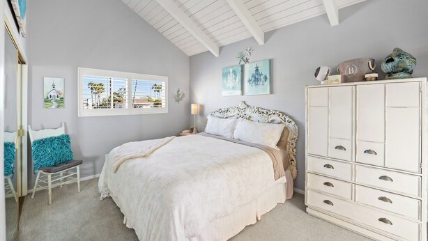 A bedroom with a bed, dresser, and artwork on the wall. - 2405O Meet Me At the Jetty (Oxnard)