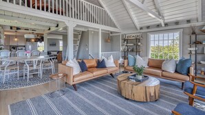 A spacious living area with a high ceiling, a dining table, two sofas, and a coffee table. - Privacy and Views on Nantucket Island (Nantucket)