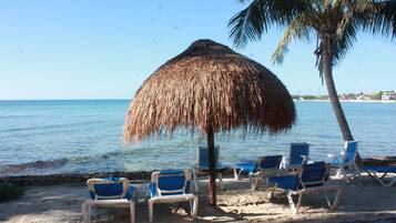Na praia, espreguiçadeiras, toalhas de praia