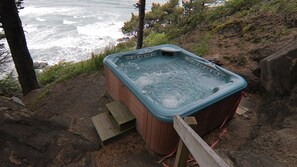 A hot tub outdoors with a view of the ocean.