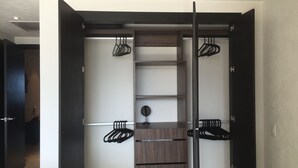 A walk-in closet with a mirrored wardrobe, shelves, and hanging space.