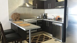 A modern kitchen with a stainless steel stove, a microwave, and a refrigerator.